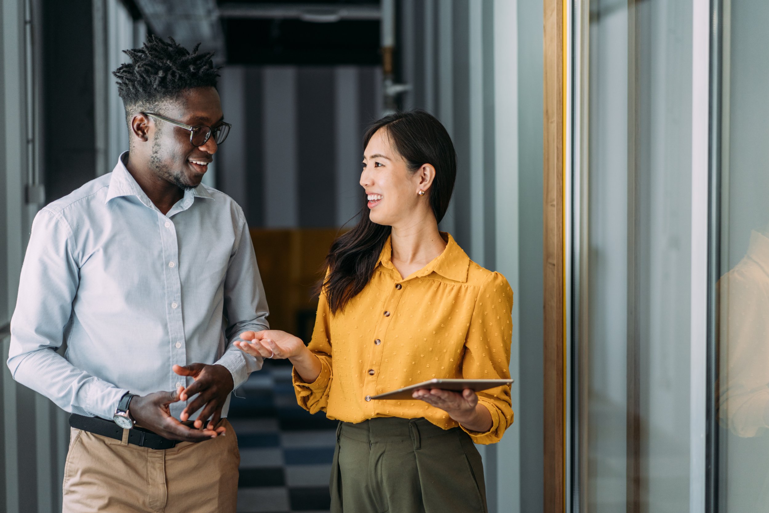 Coworkers laughing in a hallway.
