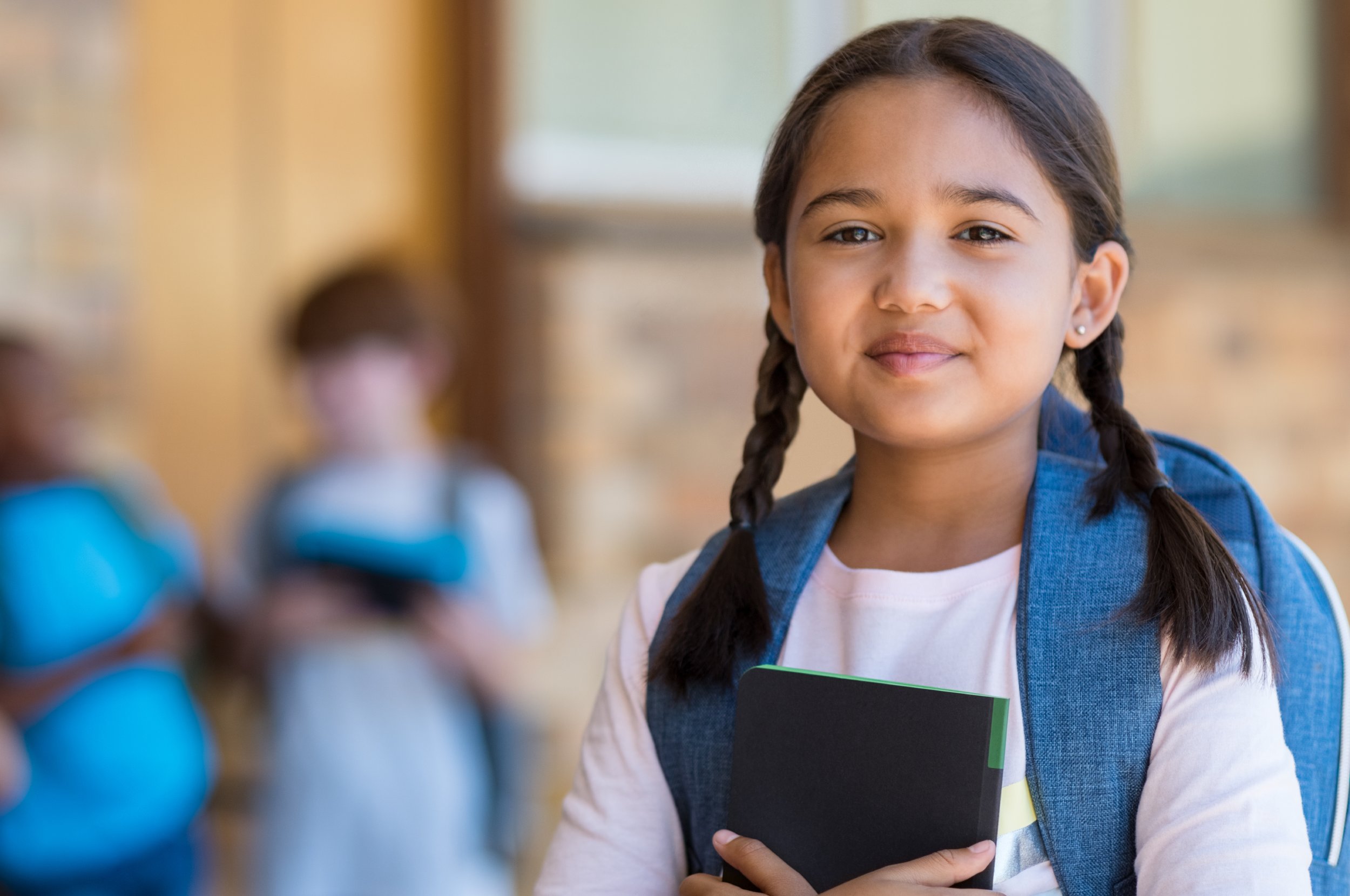 Little girl with ponytails smiling.